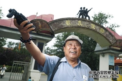 北京電影廠外，趙士軒用閃光燈打亮自己。平時，他都坐在這里等待演戲機會。趙士軒曾是一名法官，退休后為圓演戲夢，成為北影廠門口的一名群演。